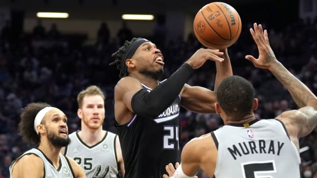 Dec 19, 2021; Sacramento, California, USA; Sacramento Kings guard Buddy Hield (24) shoots over San Antonio Spurs guard Dejounte Murray (5) during the fourth quarter at Golden 1 Center. Mandatory Credit: Darren Yamashita-USA TODAY Sports